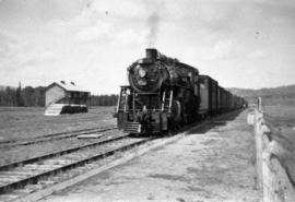 Steam locomotive, track and a building in an unknown location