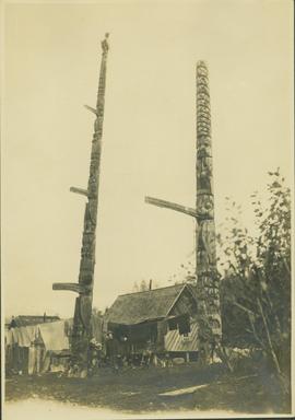 Man standing between two totem poles