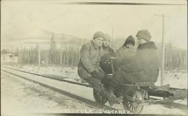 Four men ride a railway track speeder in the winter